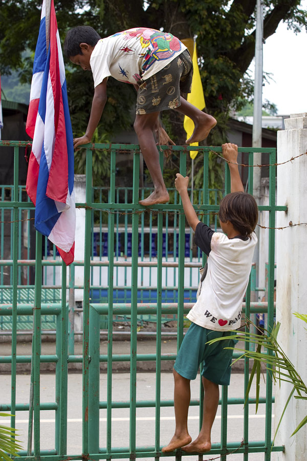 Burmese kids climbing the border fence into Thailand at Mae Sai