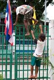 Burmese children at the Mae Sai border in Thailand climbing the border fence - Click for larger image